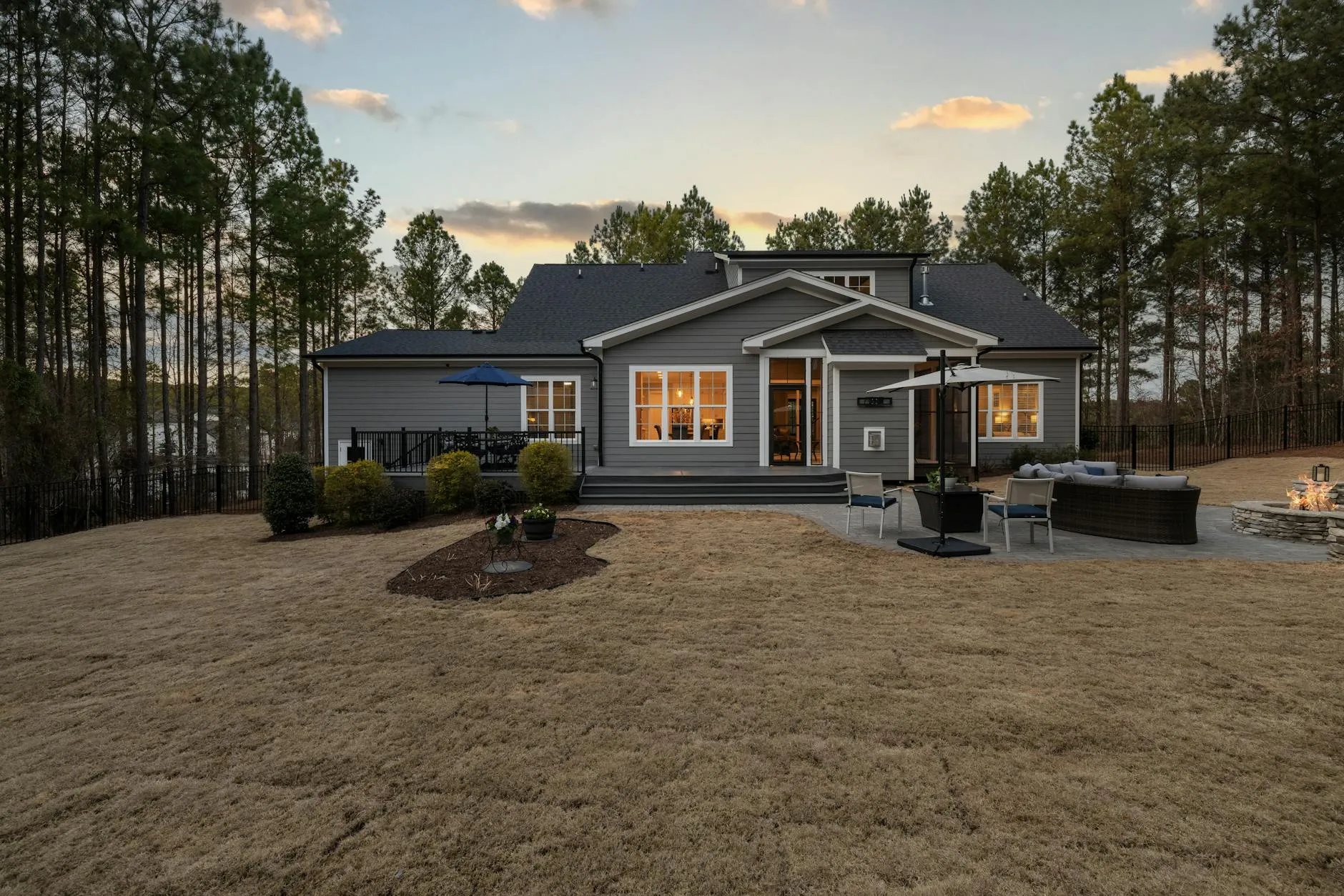 Tuin met natuursteen terras en strakke beplanting in de avondzon